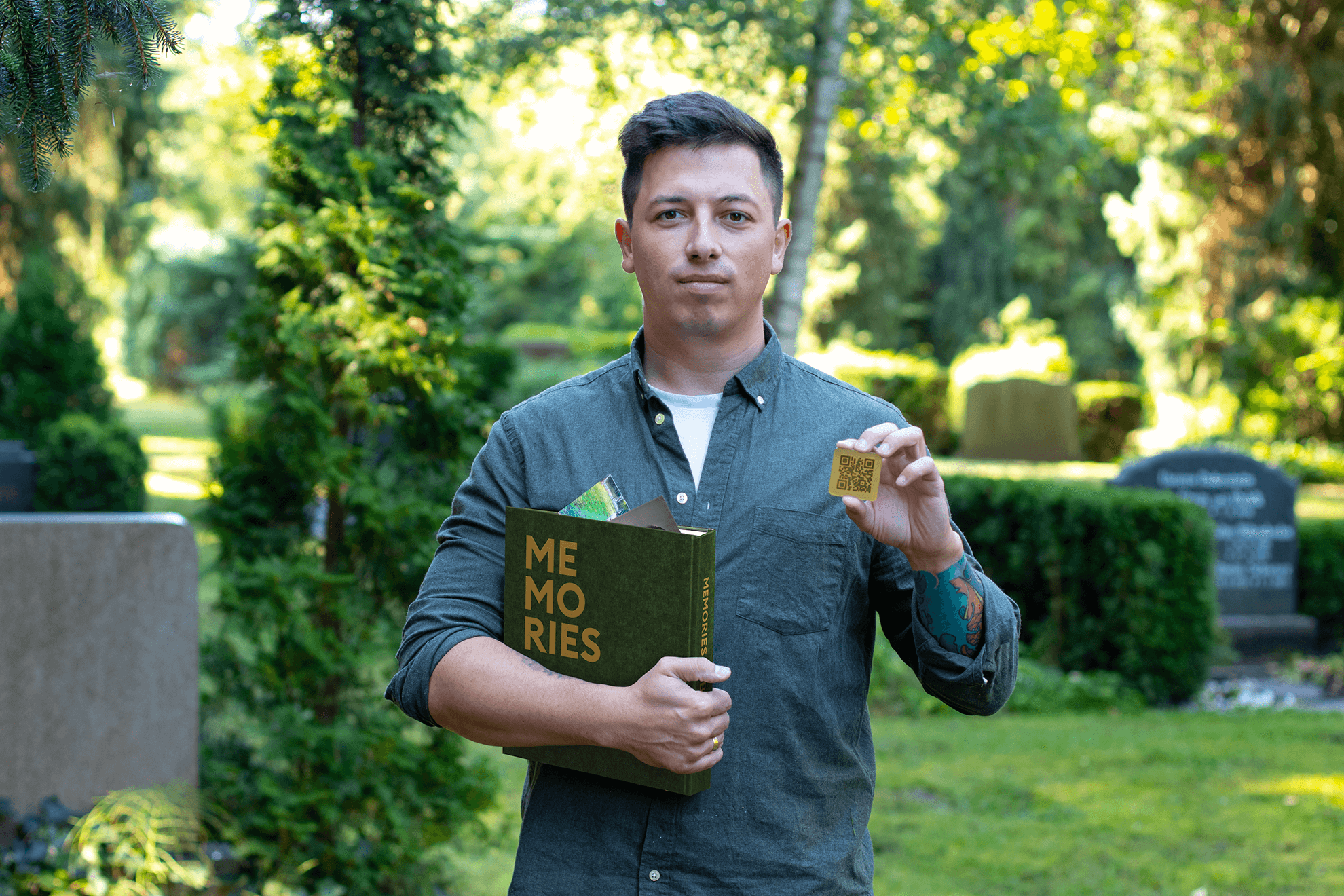 Засновник діджитал-меморіалу тримає книгу памʼяті та qr-код